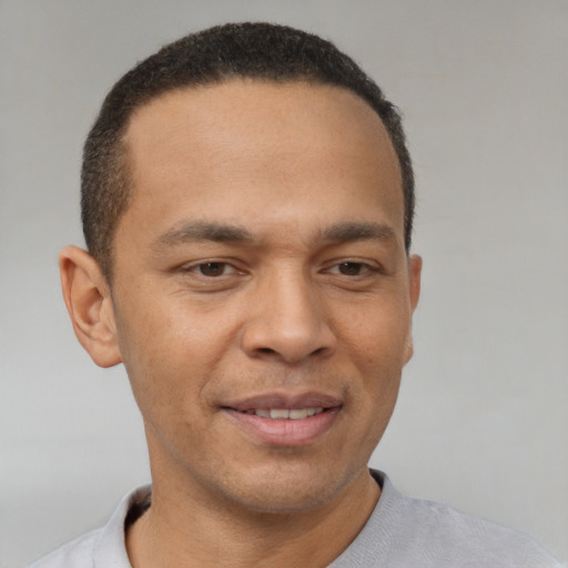 Joyful latino young-adult male with short  brown hair and brown eyes