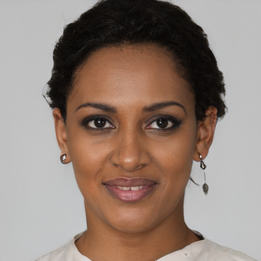 Joyful black young-adult female with short  black hair and brown eyes