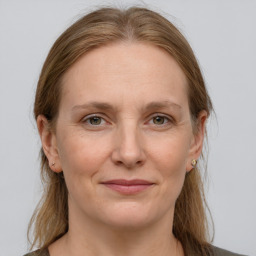 Joyful white adult female with long  brown hair and grey eyes