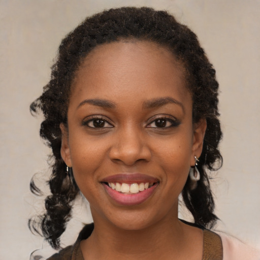 Joyful black young-adult female with medium  brown hair and brown eyes