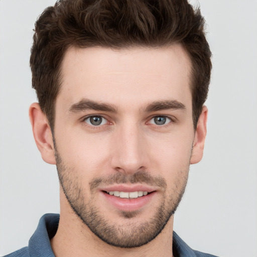 Joyful white young-adult male with short  brown hair and grey eyes