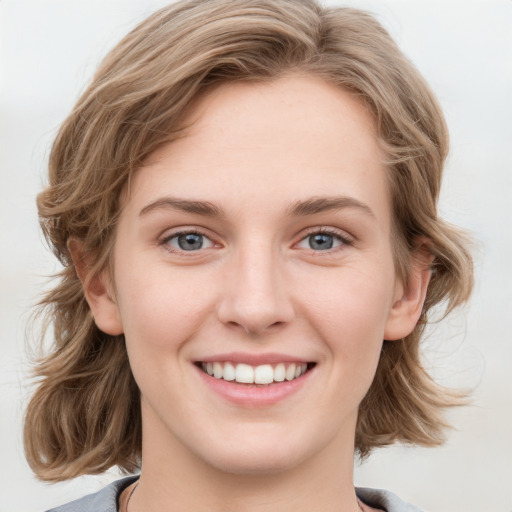 Joyful white young-adult female with medium  brown hair and blue eyes