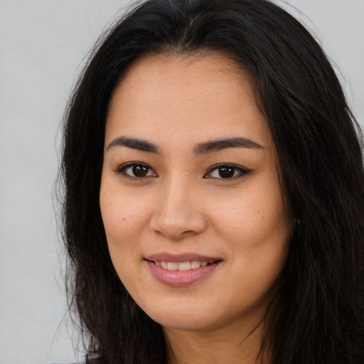 Joyful asian young-adult female with long  brown hair and brown eyes