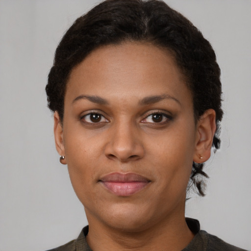 Joyful black young-adult female with short  brown hair and brown eyes