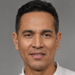 Joyful latino adult male with short  black hair and brown eyes