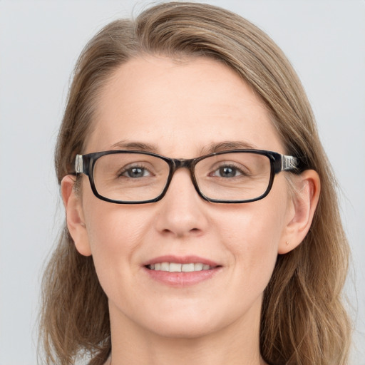 Joyful white adult female with long  brown hair and blue eyes