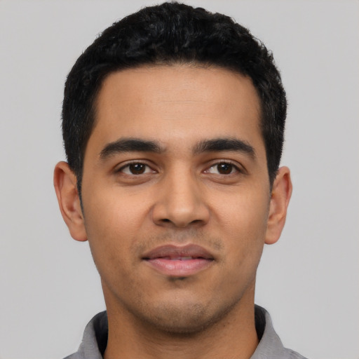 Joyful latino young-adult male with short  black hair and brown eyes