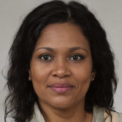 Joyful black adult female with long  brown hair and brown eyes