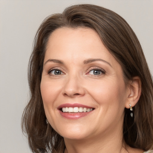 Joyful white adult female with medium  brown hair and grey eyes