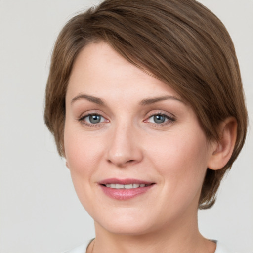 Joyful white young-adult female with medium  brown hair and grey eyes