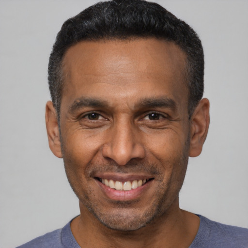 Joyful latino adult male with short  black hair and brown eyes