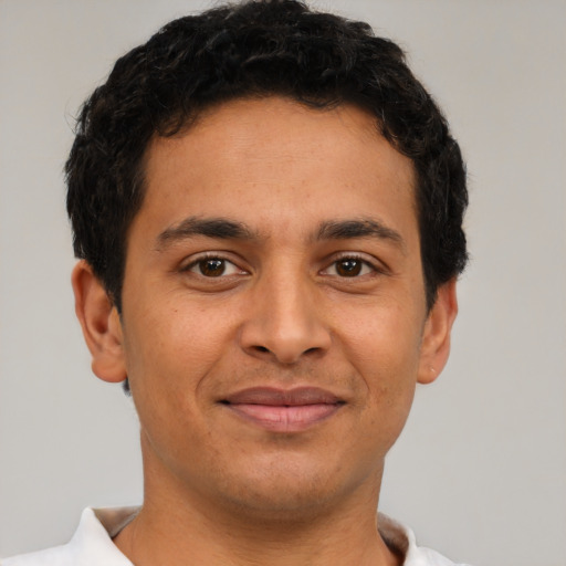 Joyful latino young-adult male with short  brown hair and brown eyes