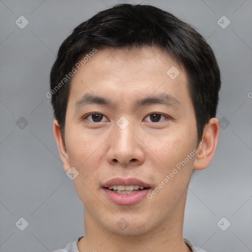 Joyful asian young-adult male with short  brown hair and brown eyes