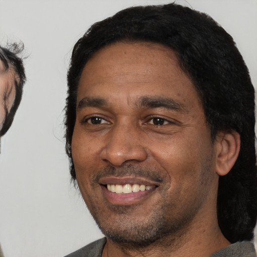 Joyful black adult male with short  black hair and brown eyes