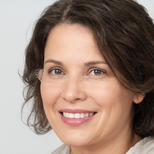 Joyful white adult female with medium  brown hair and grey eyes