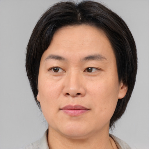 Joyful asian young-adult female with medium  brown hair and brown eyes