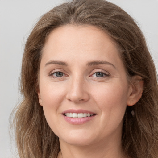 Joyful white young-adult female with long  brown hair and grey eyes