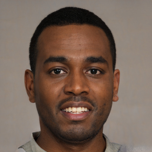Joyful black young-adult male with short  black hair and brown eyes
