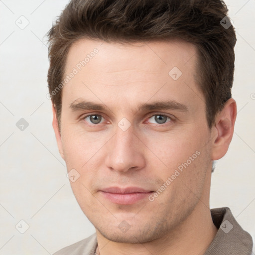 Joyful white young-adult male with short  brown hair and grey eyes