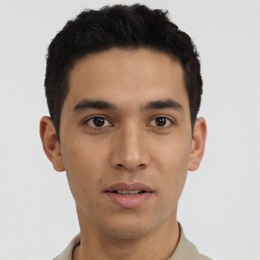 Joyful latino young-adult male with short  brown hair and brown eyes