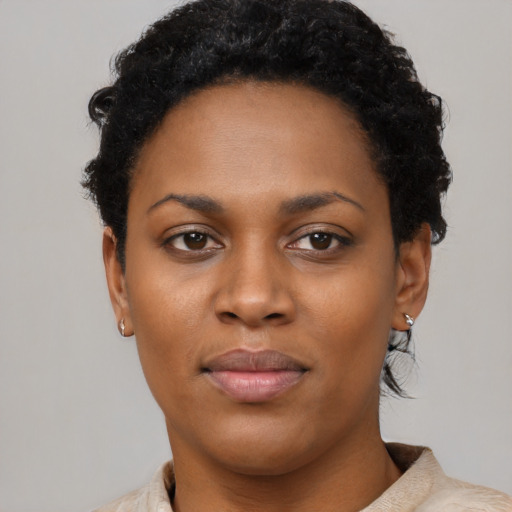 Joyful black young-adult female with short  black hair and brown eyes