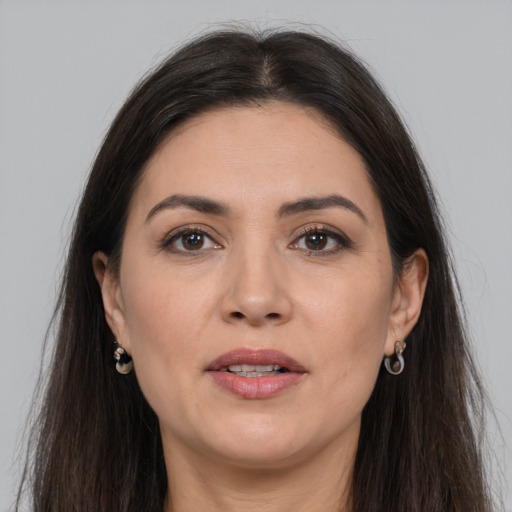 Joyful white adult female with long  brown hair and brown eyes