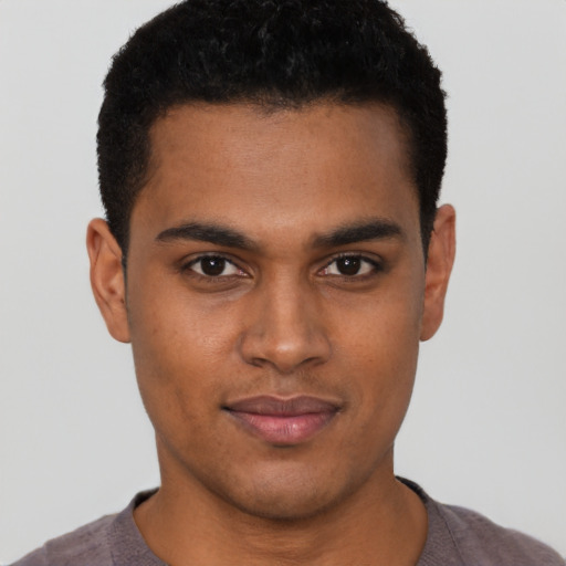 Joyful black young-adult male with short  brown hair and brown eyes