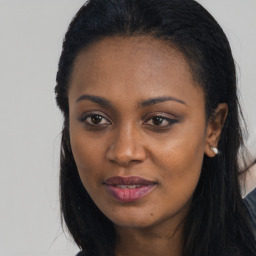 Joyful black young-adult female with long  brown hair and brown eyes