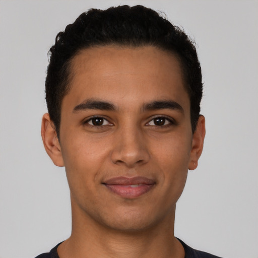 Joyful latino young-adult male with short  brown hair and brown eyes