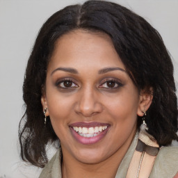 Joyful black adult female with medium  brown hair and brown eyes