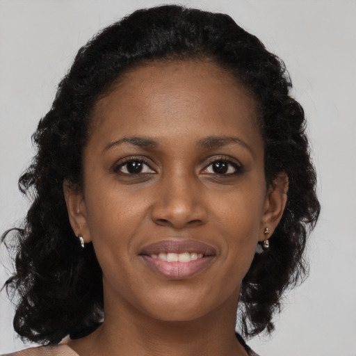 Joyful black young-adult female with long  brown hair and brown eyes