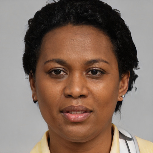 Joyful black adult female with short  black hair and brown eyes