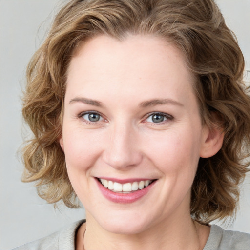 Joyful white young-adult female with medium  brown hair and blue eyes