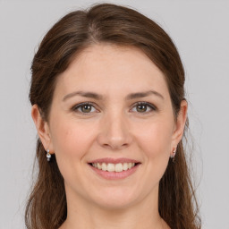 Joyful white young-adult female with long  brown hair and grey eyes