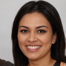 Joyful latino young-adult female with long  brown hair and brown eyes