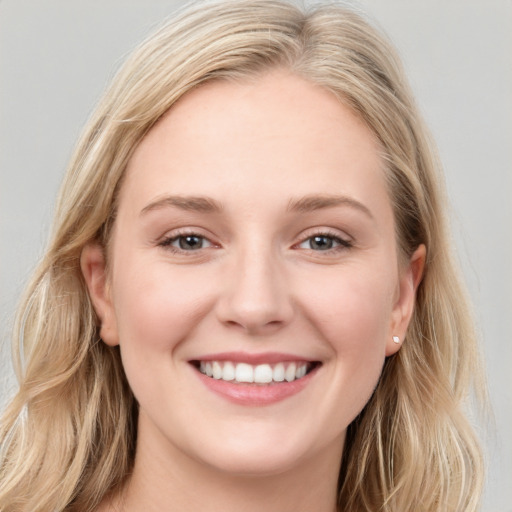 Joyful white young-adult female with long  brown hair and blue eyes