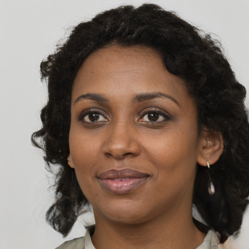 Joyful black young-adult female with long  black hair and brown eyes