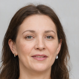 Joyful white adult female with long  brown hair and grey eyes