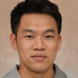 Joyful asian young-adult male with short  brown hair and brown eyes