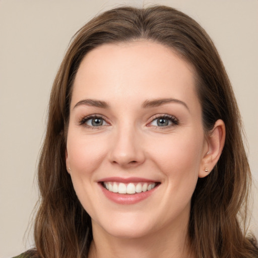 Joyful white young-adult female with long  brown hair and green eyes