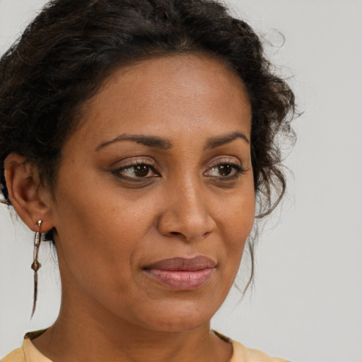 Joyful black adult female with medium  brown hair and brown eyes