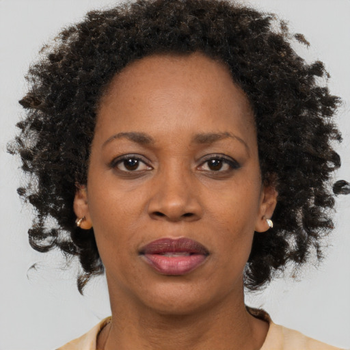 Joyful black adult female with medium  brown hair and brown eyes
