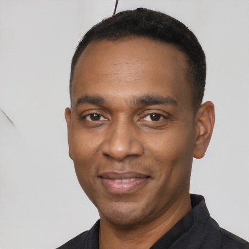 Joyful black young-adult male with short  black hair and brown eyes