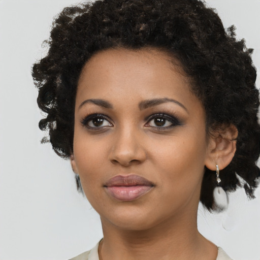 Joyful black young-adult female with short  black hair and brown eyes