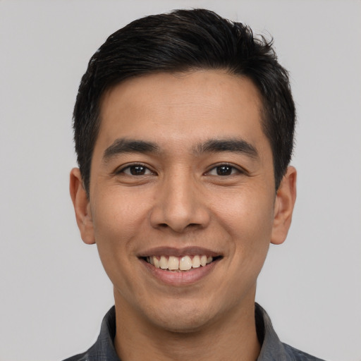 Joyful latino young-adult male with short  black hair and brown eyes