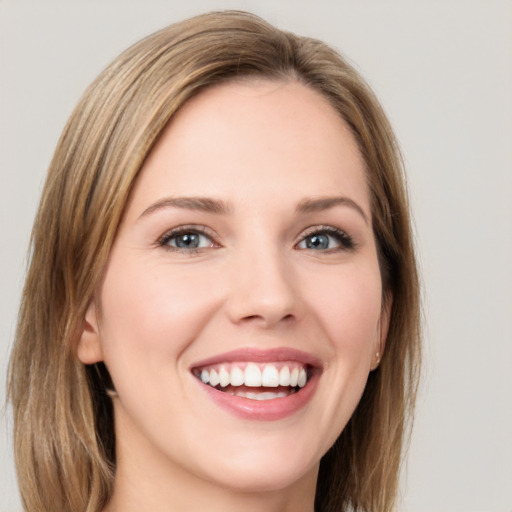 Joyful white young-adult female with long  brown hair and green eyes