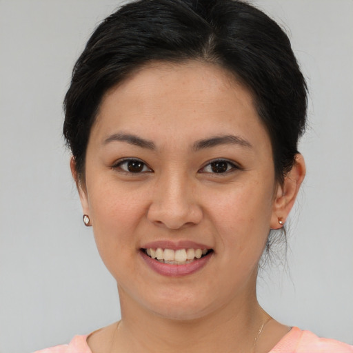 Joyful asian young-adult female with short  brown hair and brown eyes