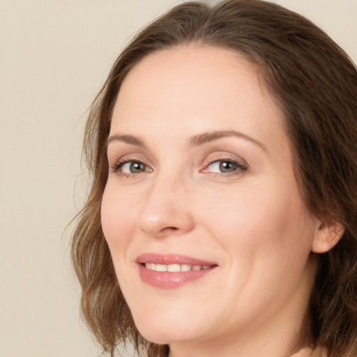 Joyful white adult female with medium  brown hair and green eyes