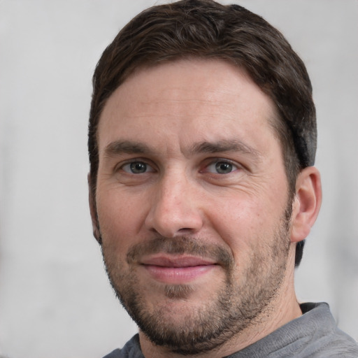 Joyful white adult male with short  brown hair and grey eyes