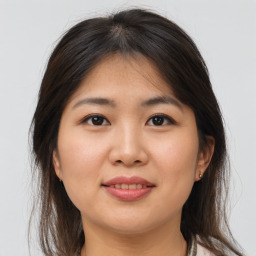 Joyful asian young-adult female with medium  brown hair and brown eyes